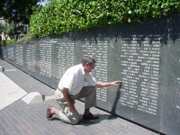 Man kneeling at the Kansas Vietnam War Memorial